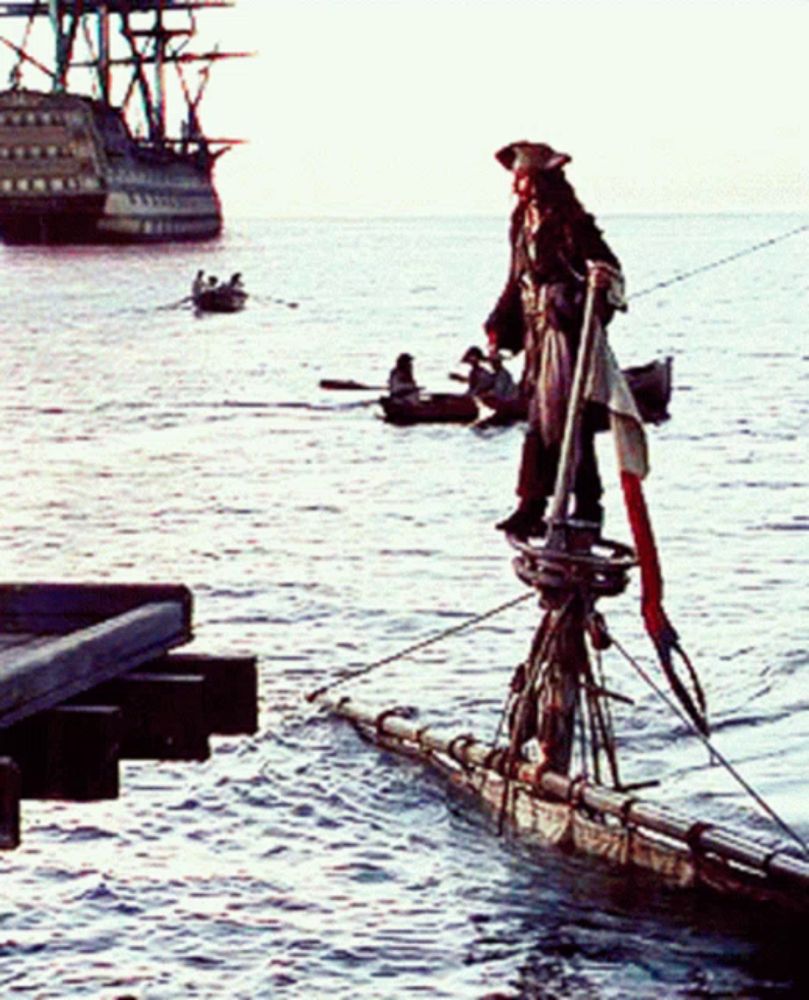 a man in a pirate costume is standing on a raft in the water