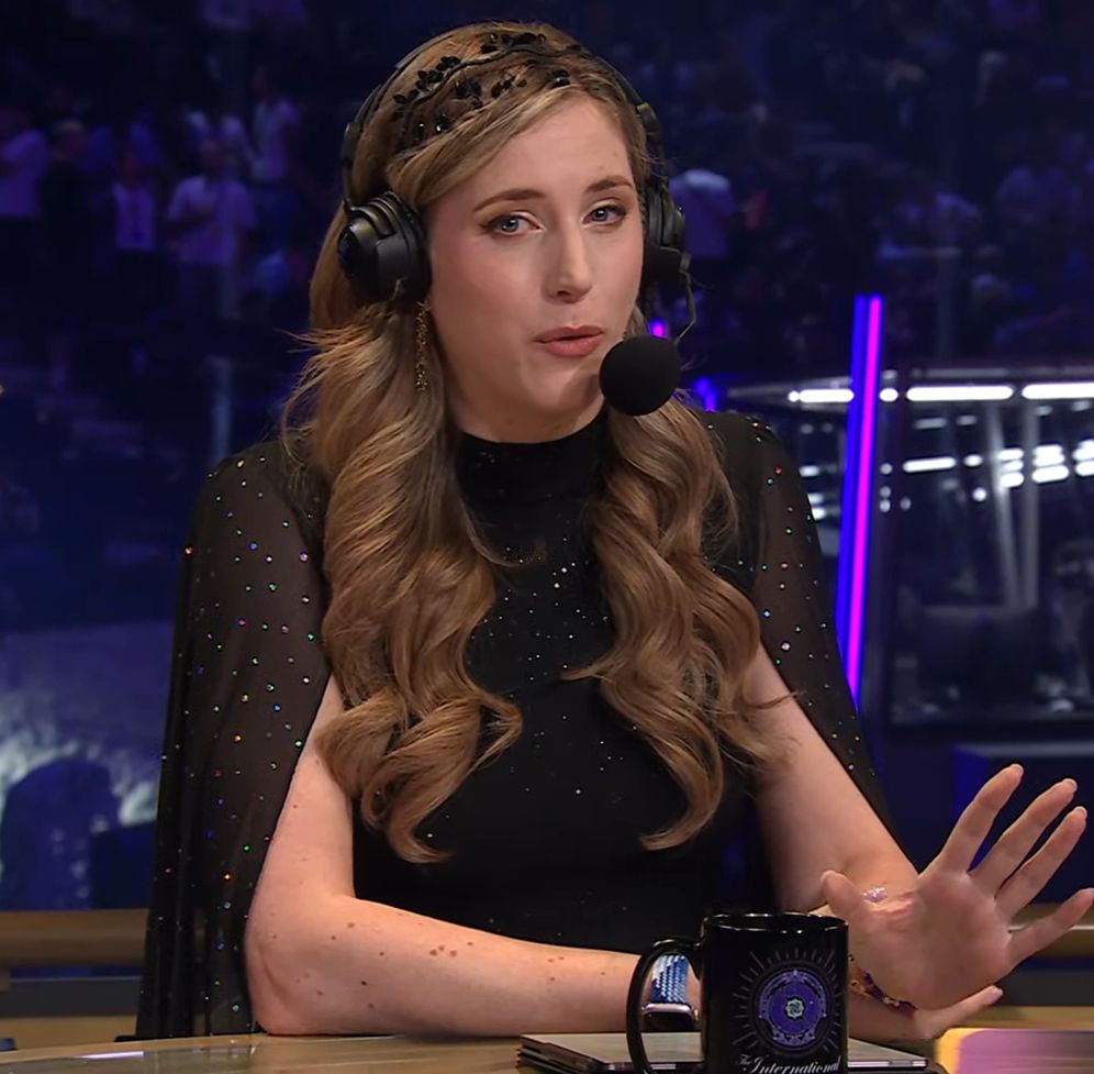 Sheever at the host desk.

She's wearing this glittery dress (I think), solid black at the torso with this sheer cloak thing going on over the sleeves. To complement it she has (also glittery) black leaf jewelry in her hair, which otherwise has incredible rich curls.