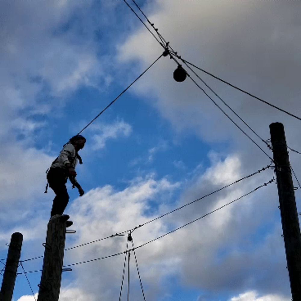 a person is hanging upside down from a ropes course