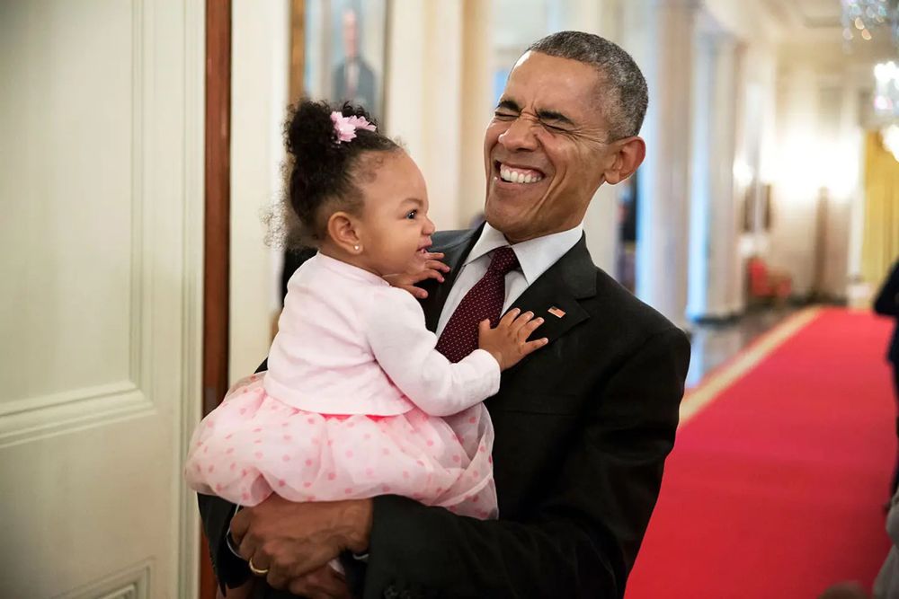 Obama holds the daughter of former staff member Darienne Page Rakestraw in the Cross Hall of the White House, on April 3, 2015. Pete Souza—The White House