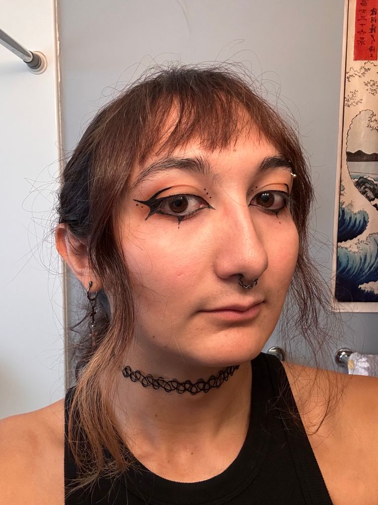 Me with sharp eyeliner with multiple points and a few dots