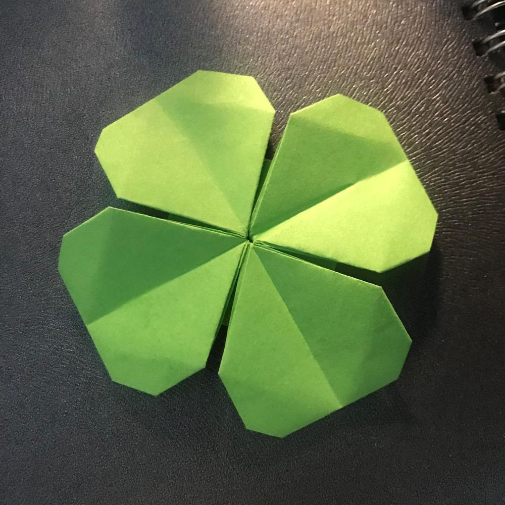 The flat shape of a four-leaf clover origami, viewed from above. Both four-leaf clovers are green in color