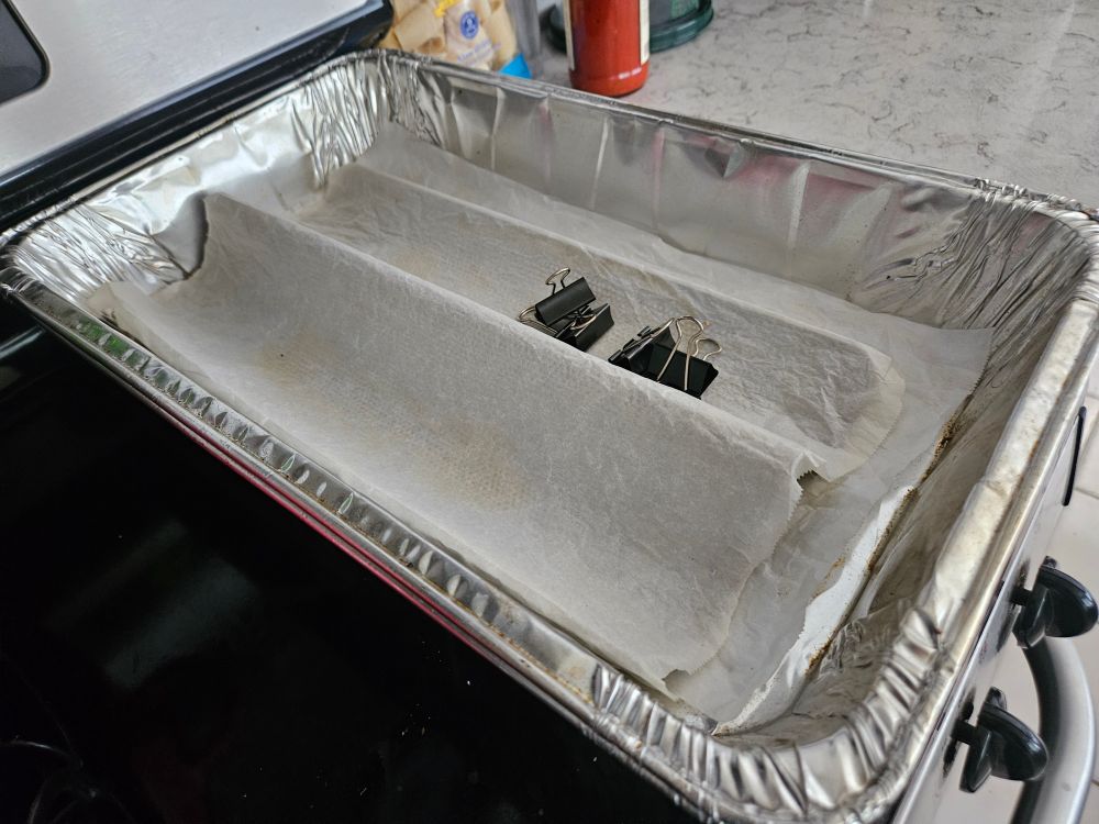 HACK: Oversized cloche (baking/steaming enclosure) using two disposable aluminum roasting pans, a tin foil tray w/wet paper towel, and four bulldog clips. 