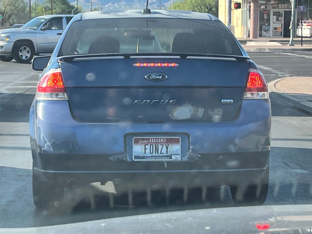 A blue Ford Escape with an Idaho license plate that reads Fonzy.
