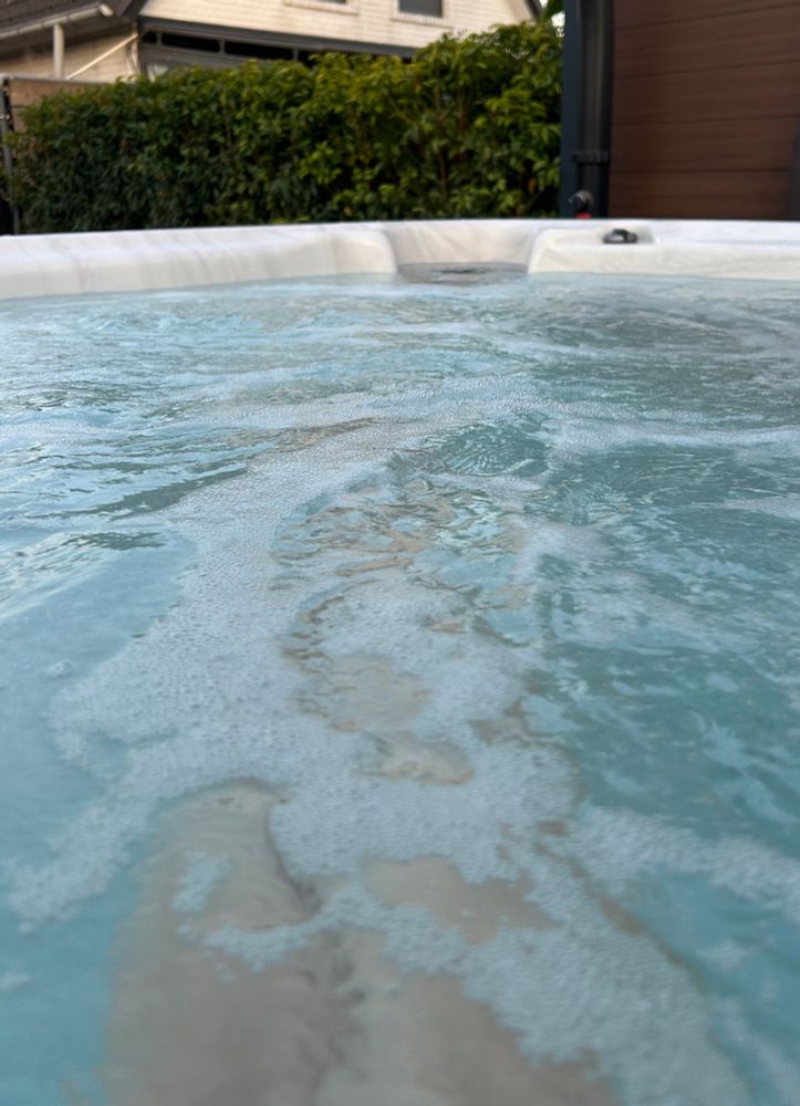 Beine durch durch Wasser scheinen in einem Whirlpool der in einem Garten steht. 