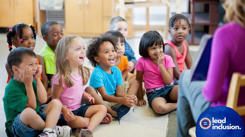 Young children seated on floor, laughing and smiling as they listen to a teacher. Lead Inclusion logo in corner.