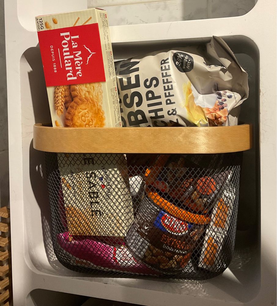 Süßigkeiten im Korb: Kekse, Chips, Nüsse, Bonbons