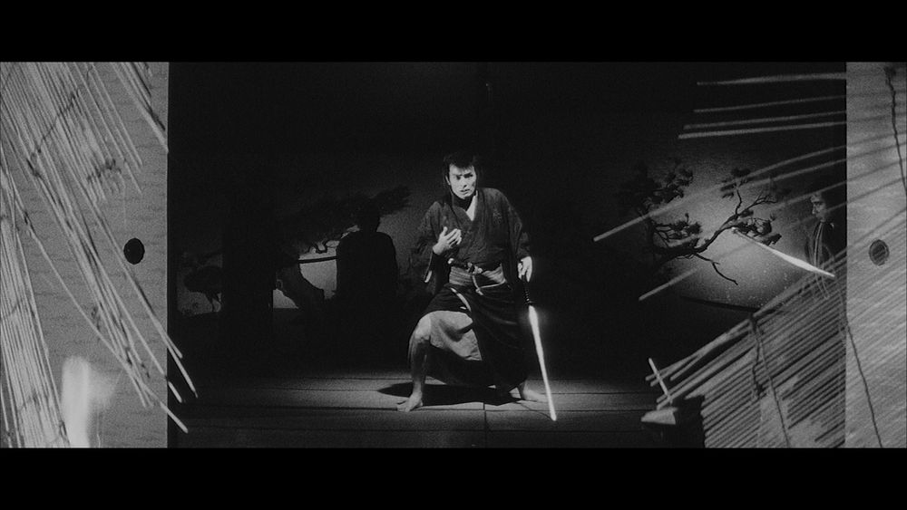 Screenshot from the movie "The Sword of Doom" showing a beat up samurai with a very pained and serious look on his face, surrounded by shadows of other samurai.