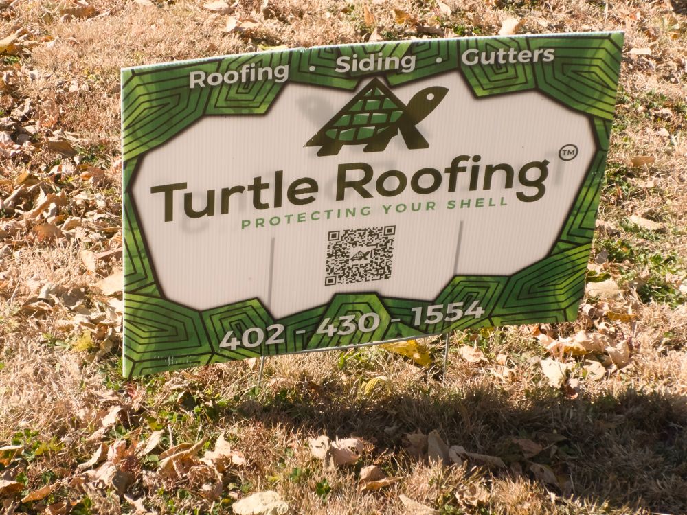 Turtle Roofing advertising sign in the yard of a newly roofed house