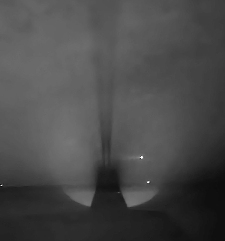 At the back of the Roger Casement statue at the Dun Laoghaire baths, looking down the line of the spotlight, north into Dublin bay. Casement's shadow in the night air. Black and white. 