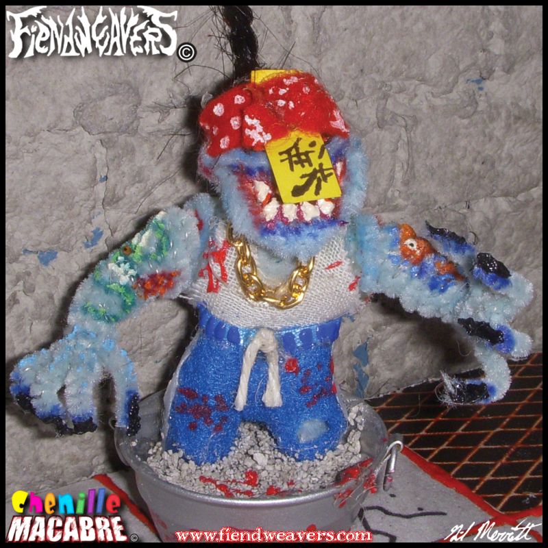 A pipe cleaner figure I built of Yan Mo, an original character from my tabletop splatter fighting game AMPUTHEATRE. Yan Mo is a light blue vampire in a wife beater and blue gym pants with a gold chain and red bandana. A paper talisman hides his eyes, and his feet are trapped in a cement tub. His arms are tattooed and end in long sharp claws. He is splashed in blood and stands 3" (7.62 cm) high.