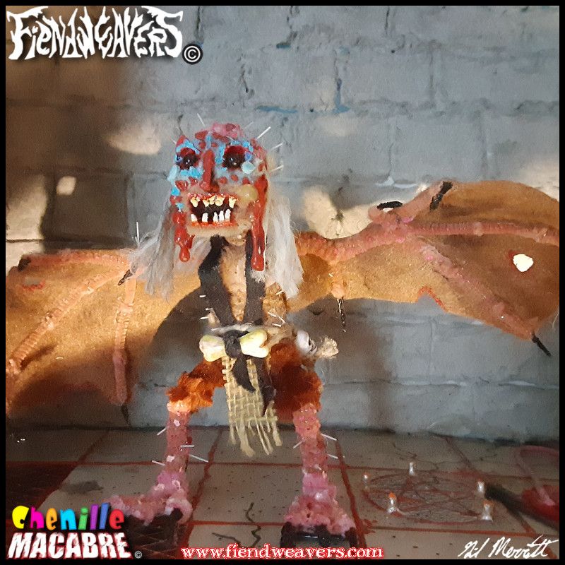 A pipe cleaner figure I built of a Harpy. She has wings on her arms and vulture facial coloration and wattles. She stands 5" (12.7 high) with an 8" (20.24 cm) wingspan.