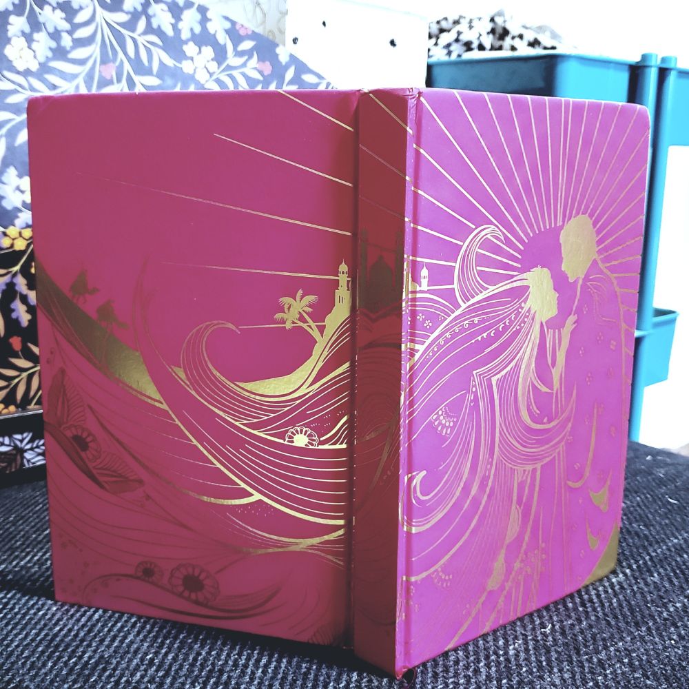 The pink and gold hardcover of the UK edition of EK Johnston's A Thousand Nights