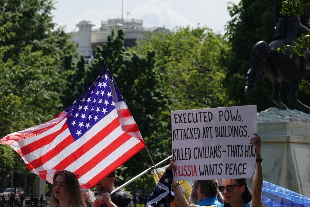 Sign says: EXECUTED POWs, ATTACKED APT. BUILDINGS, KILLED CIVILIANS - THAT'S HOW RUSSIA WANTS PEACE