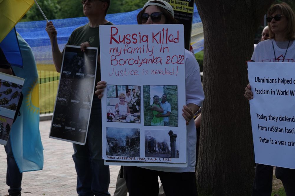 Ukranian protestor holds a sign that depicts her family members (civilians) killed by Russians in Borodyanka