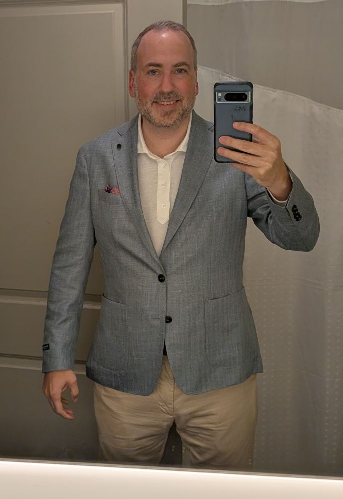 Me wearing a blue jacket, white shirt, and khaki pants.