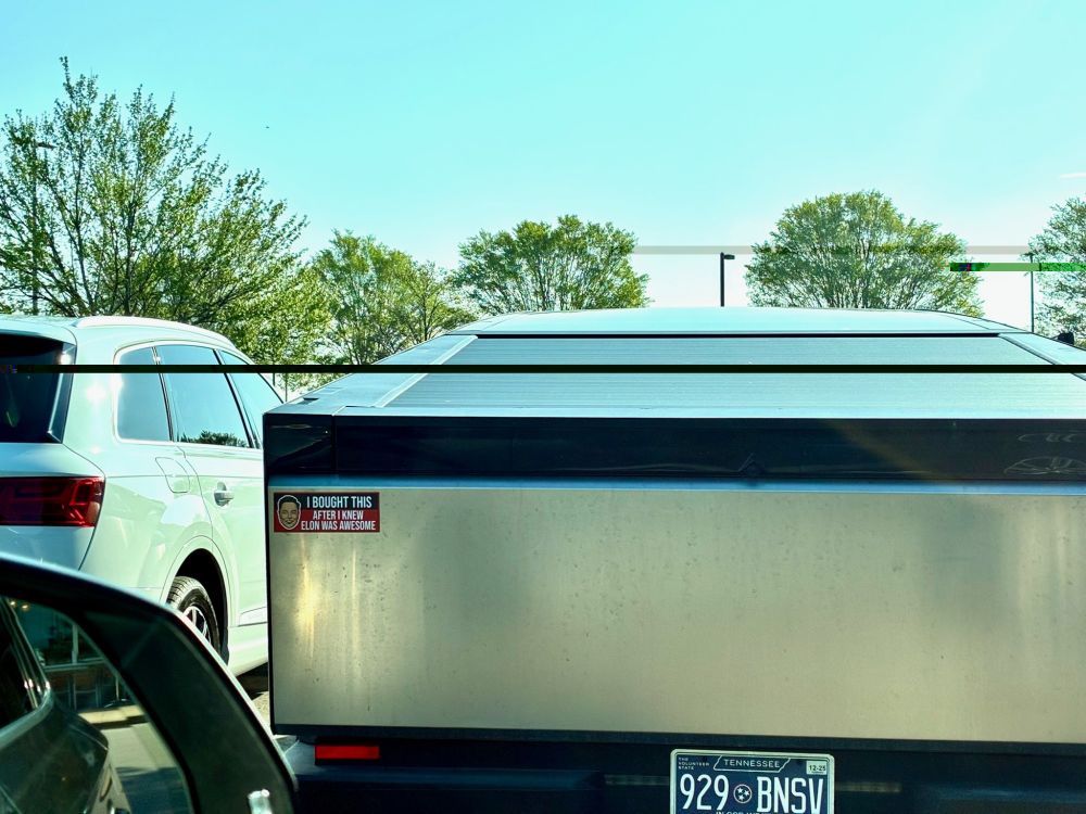 A Cybertruck with a bumper sticker that says, "I bought this after I knew that Elon was awesome." Gag.