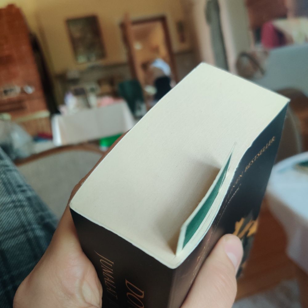 Kuva pokkarista kädessä, jossa kirjanmerkki n. kohdassa 34/745.