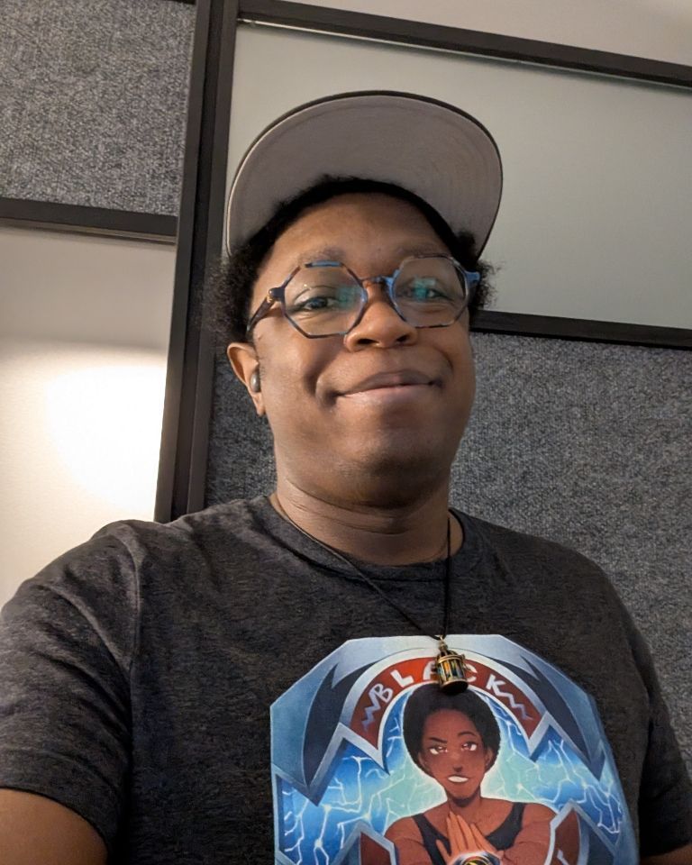Sparrow, wearing a baseball cap, his "black Sparrow" power rangers shirt, hexagonal glasses, and bird cage necklace. 