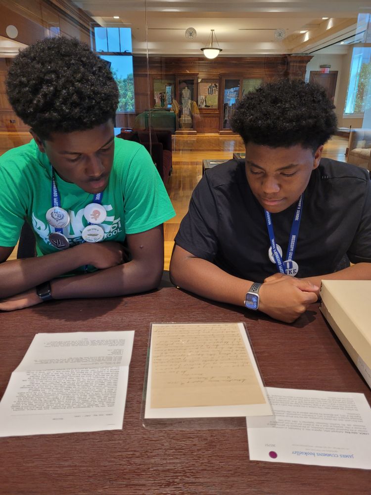 Students looking at an original letter written by writer, lawyer, and Reconstruction legislator John R. Lynch 