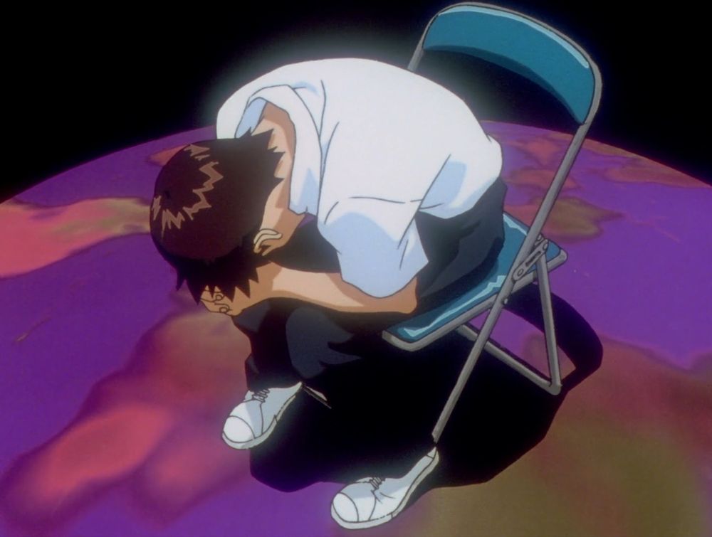 Shinji Ikari from Evangelion hunched over on a foldable metal chair