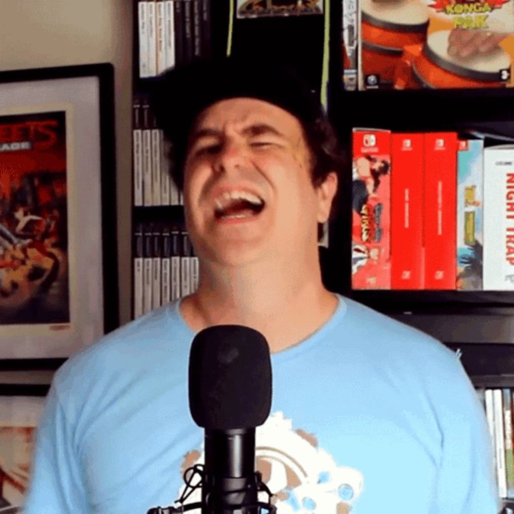 a man singing into a microphone in front of a shelf full of video games including night trap