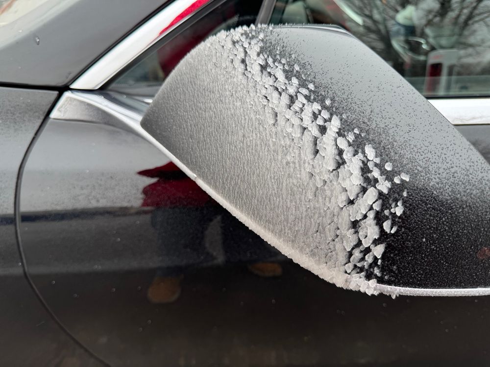 thick layer of freezing rain on the front end of a car mirror