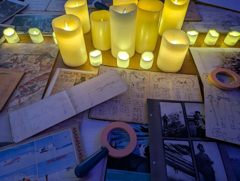 (Fake) candles and archive facsimiles on a table, including magnifying glasses.