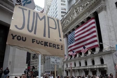 A sign written in marker on ripped cardboard that reads "JUMP! YOU FUCKERS!" rising above a crowd of people outside some kind of classically-influenced architecture draped in American flags. Is it the New York Stock Exchange? Some important bank? I dunno