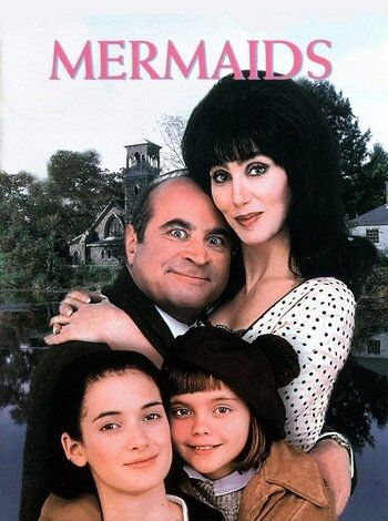 Movie poster for Mermaids. Cher & Haskins are cuddled up & Haskins is significantly shorter than Cher, the top of his head tucked into her cheek. Young Winona Ryder & Christmas Ricci are in front of them.