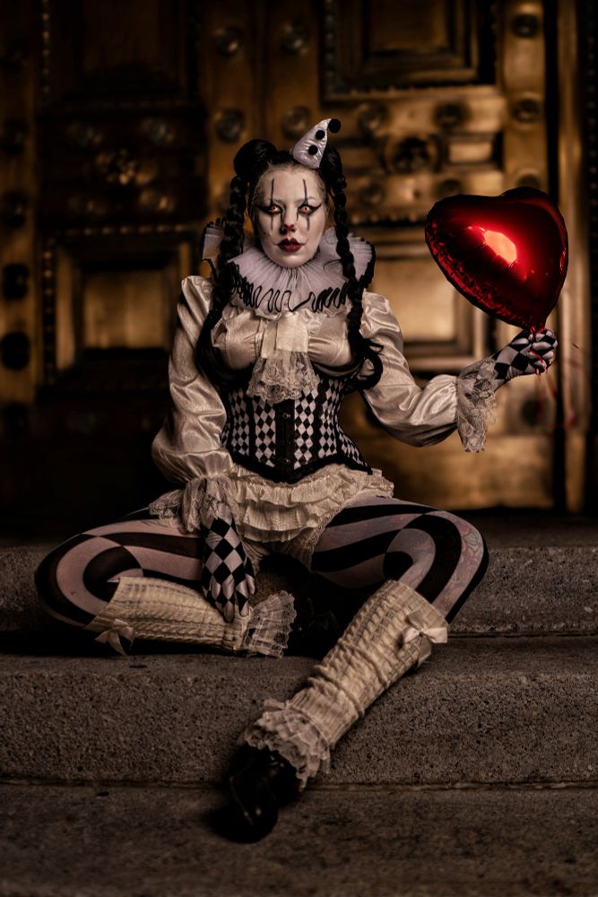 Photo of a creepy clown holding a balloon. 