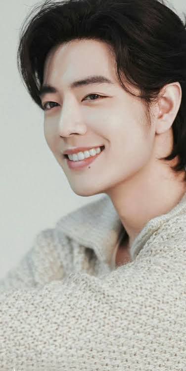 Xiao Zhan, wearing a light colored woolen sweater, smiling in the most beautiful way. 