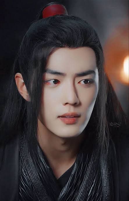 Close up of Wei Wuxian (actor Xiao Zhan, dressed in black robes) who is looking at something or someone in front of him with 
an ambiguous expression on his face - his lips 
slightly parted.