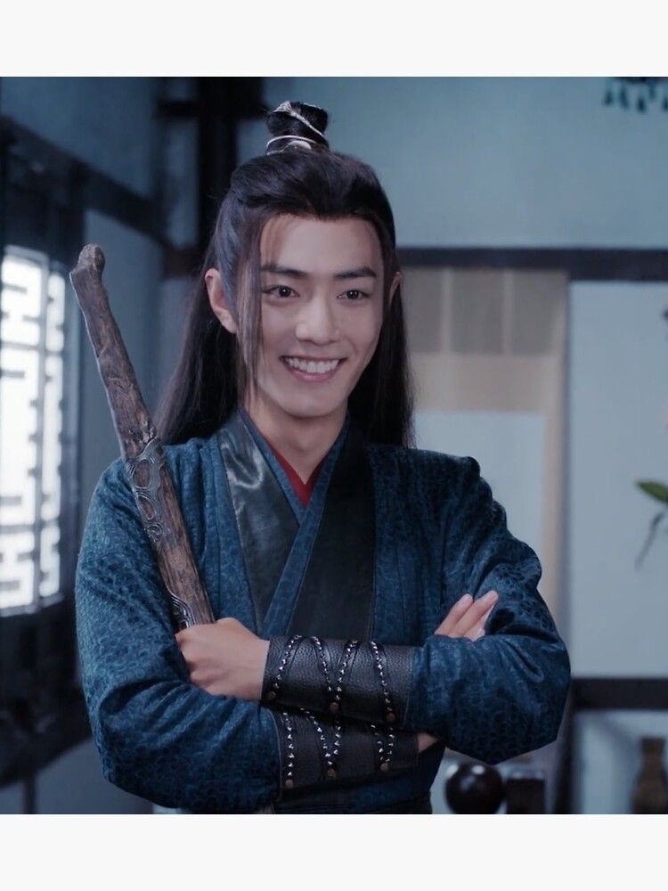 Wei Wuxian (actor Xiao Zhan, dressed in dark blue / black / red robes) who is standing with his arms crossed in front of his chest, smiling brightly and holding his sword ‚Suibian‘ in his left hand.
