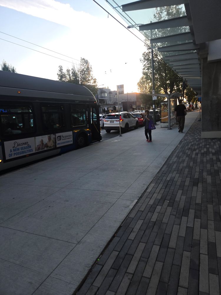 19 bus honking at a white car parked in the bus stop, right next to the shelter 