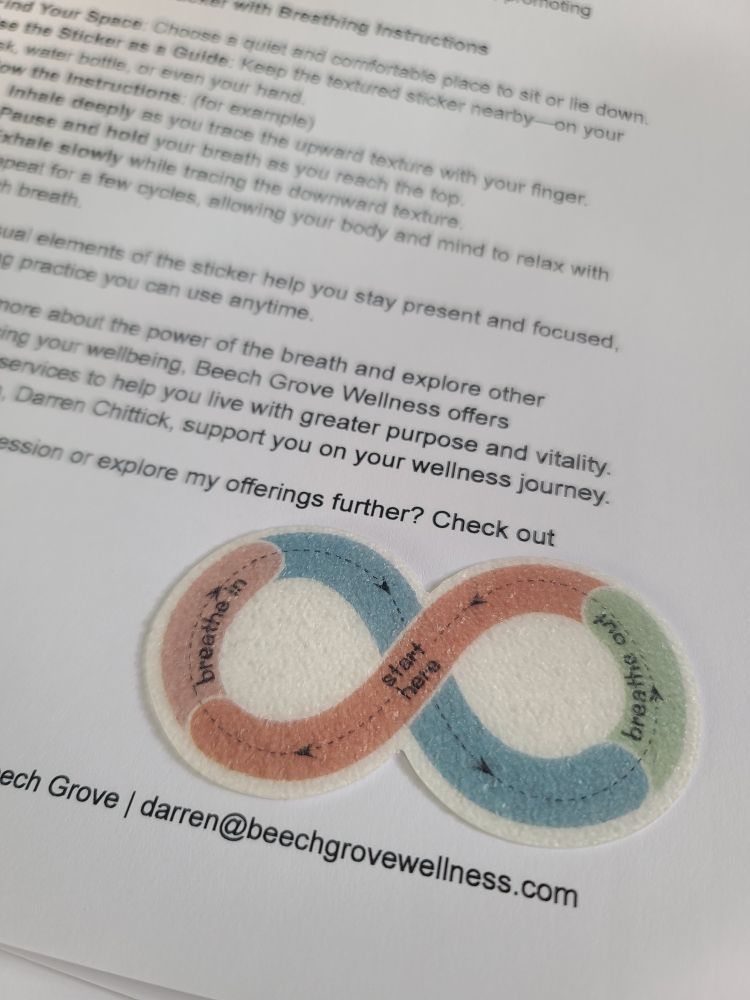 A flyer with text out of focus has a textured sticker on an infinity shape that offers instructions for inhaling and exhaling