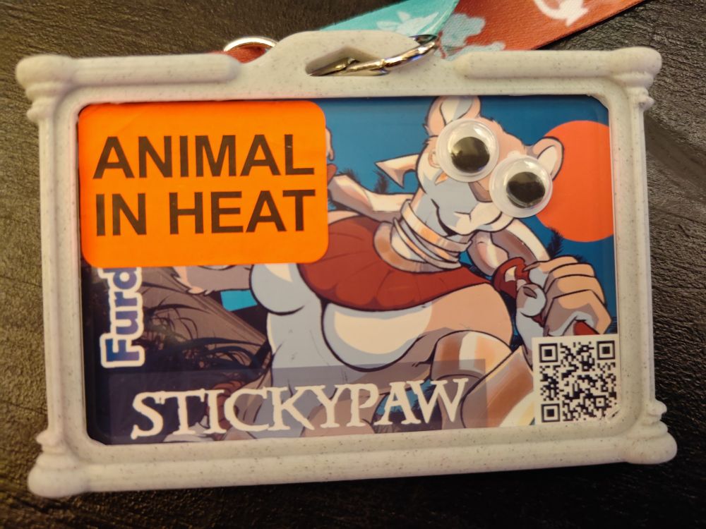 Furdu con badge with googly eyes and "animal in heat" sticker.
