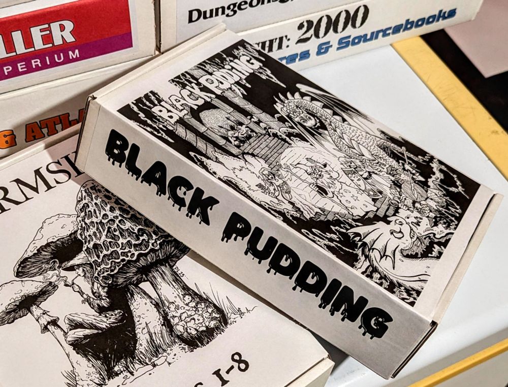 Box labeled Black Pudding with dragons and wizards on the top!