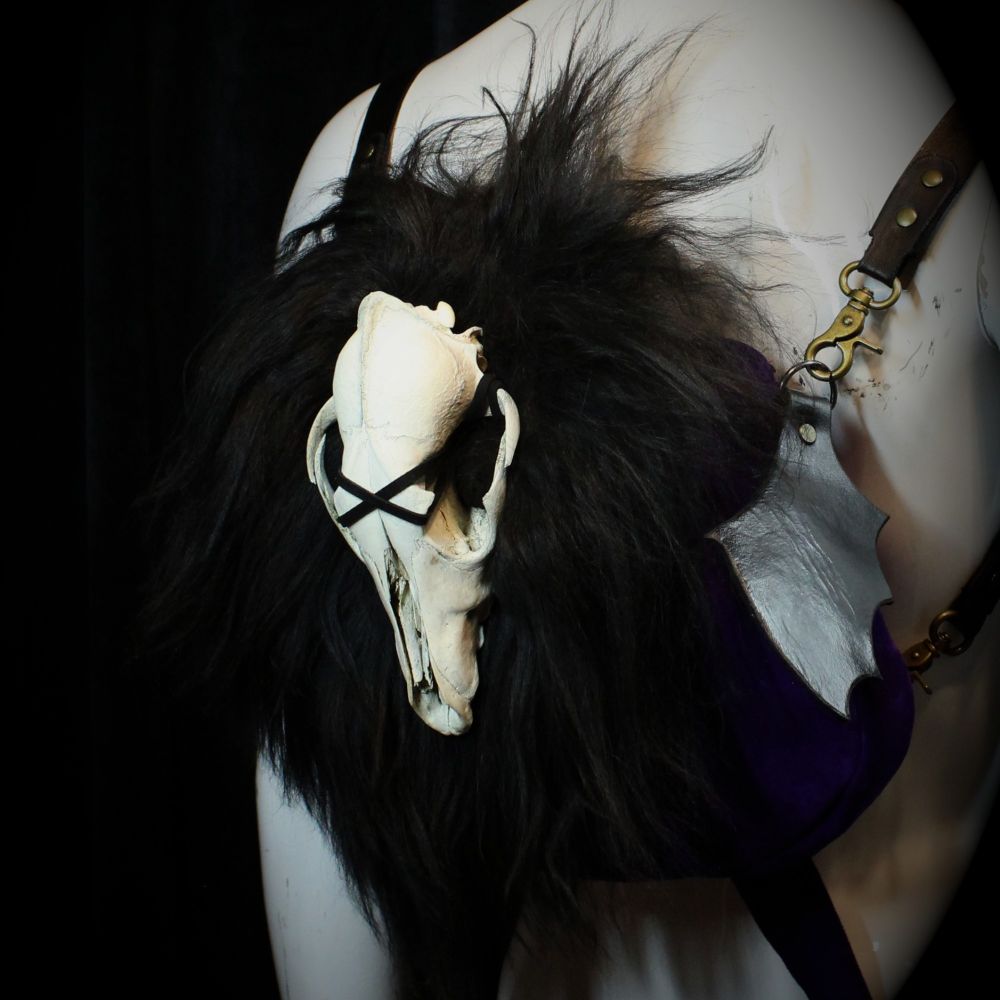 A three-quarter view of the skull backpack that shows one of the leather bat wings 