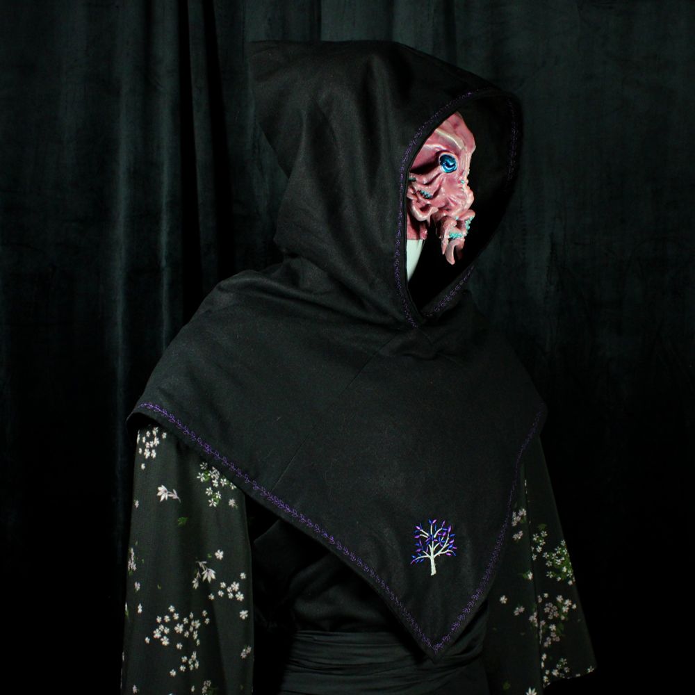 A pink octopus-like humanoid side profile. The creature wears a medieval hood layered over a floral yukata
