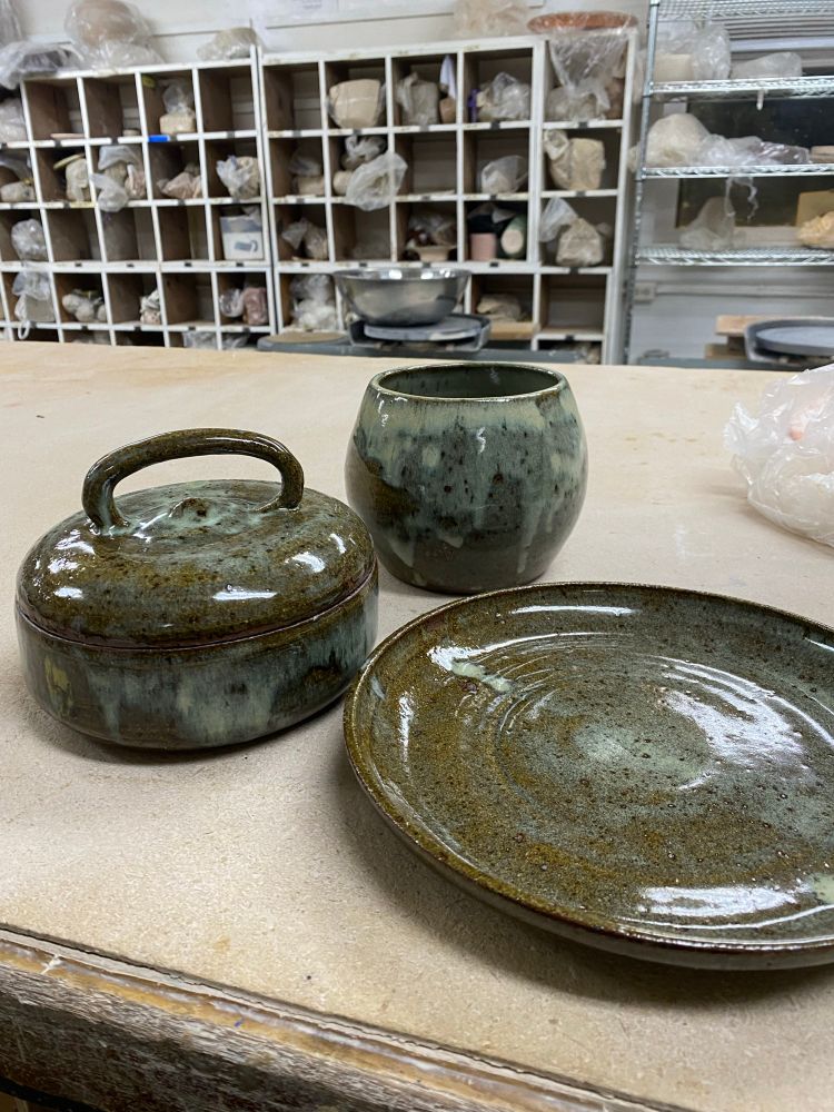 A #shayclay lidded jar with a rounded handle and rutile glaze, two pieces cut from one throw of a closed form. Matching plate and cannister alongside it