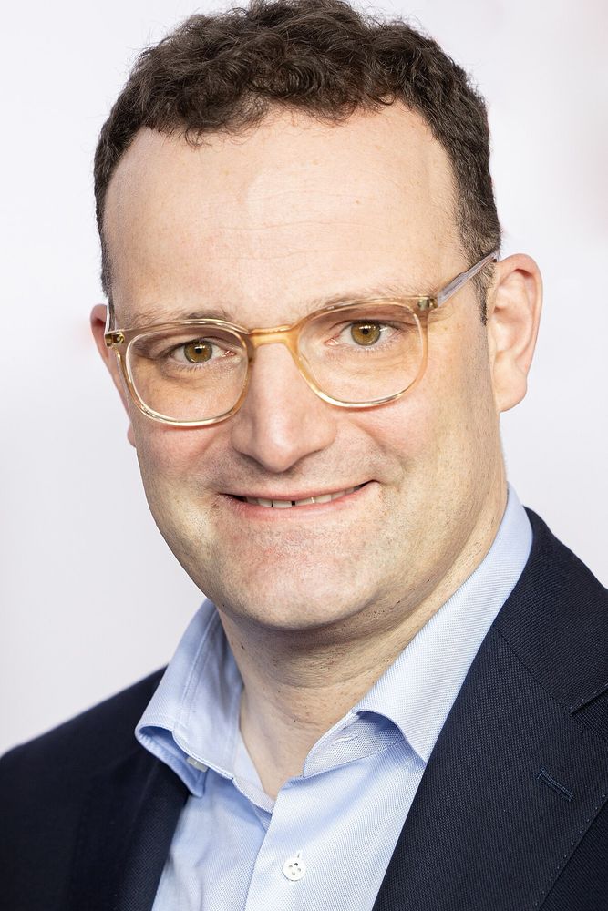 Jens Spahn grinst dumm in der Gegen rum
