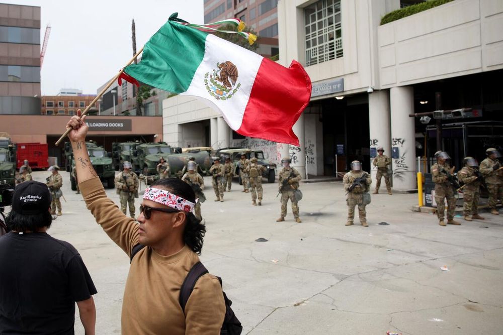 Protestor flying the Mexican flag near an ICE detention facility