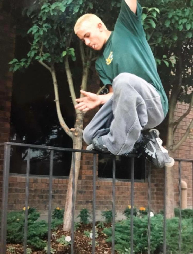 Rollerblader with baggy pants and bleached blond hair grinding a hand rail. Photo from the late 90s