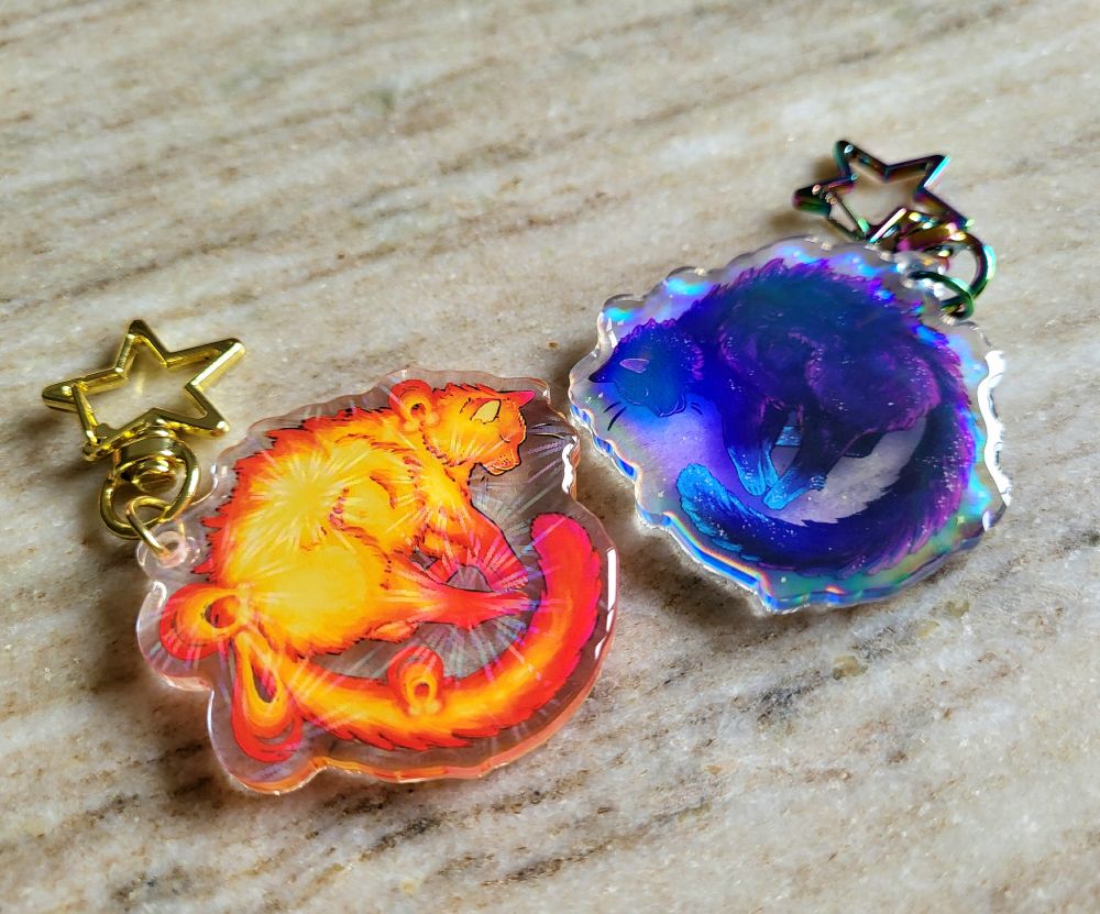 Acrylic 2" charms featuring my galaxy and sun cat artwork! They're
holographic and very vibrant in color. 