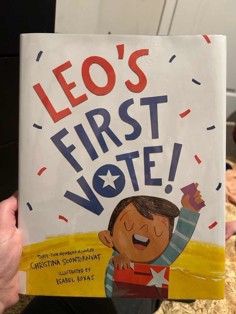 Image of a children’s book, Leo’s First Vote by Christina Soontornvat. Illustrated by Isabel Toxas. On the cover, a little boy proudly holds up his ballot in front of the ballot box, with confetti bursting around him.
