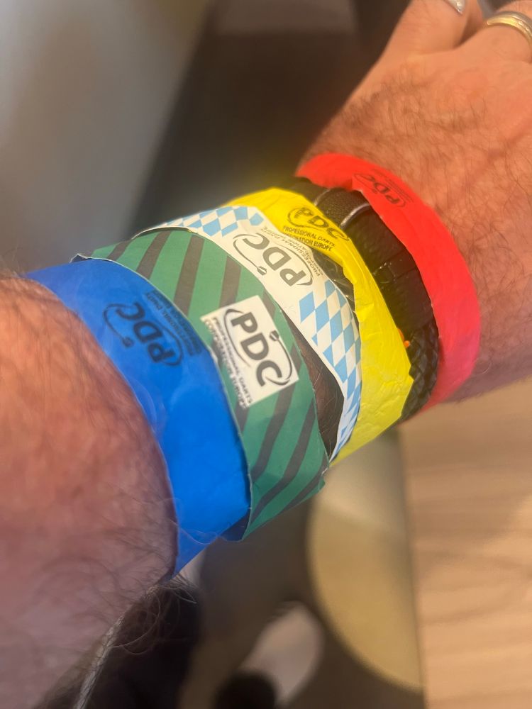 Multiple wrist bands on are from entrance to PDC darts tournament 