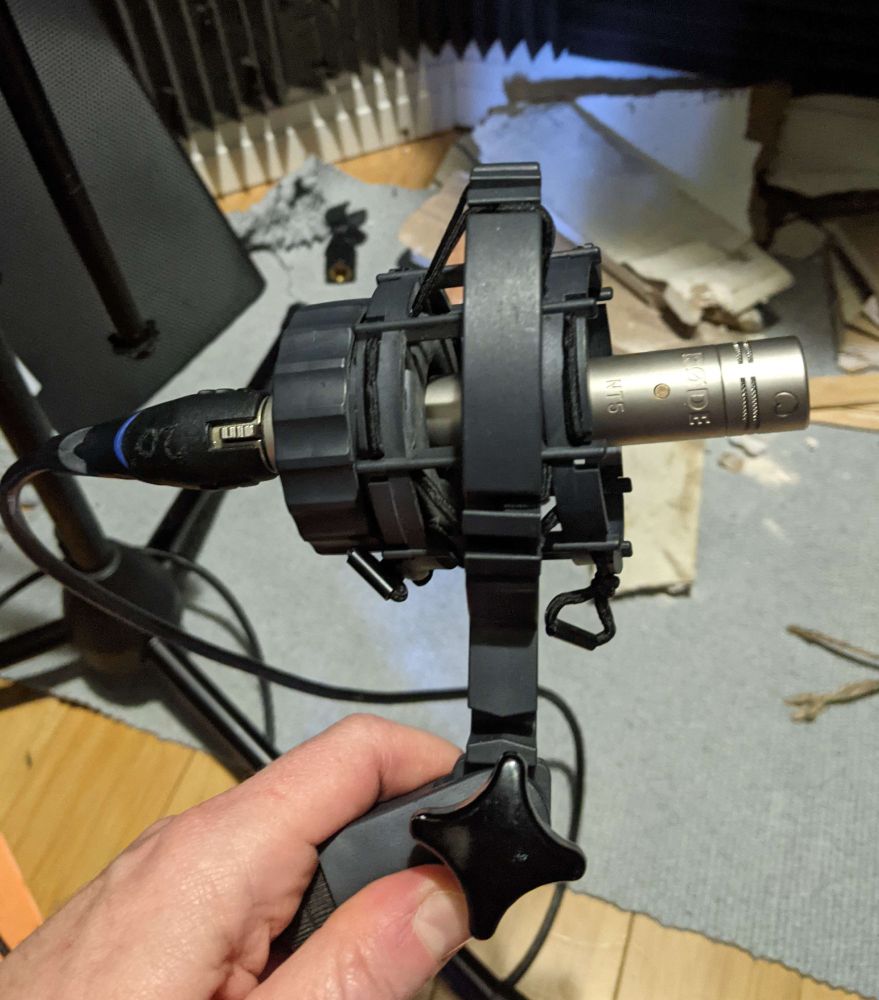 a Rode NT5 microphone held in a AKG C414's shock mount, which has seen better days.