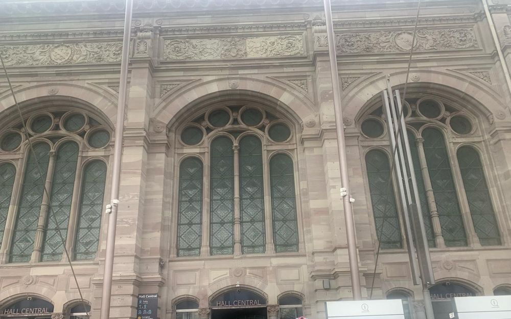 Example view of original facade of Strasbourg train station. Three arched stainless glass windows. 