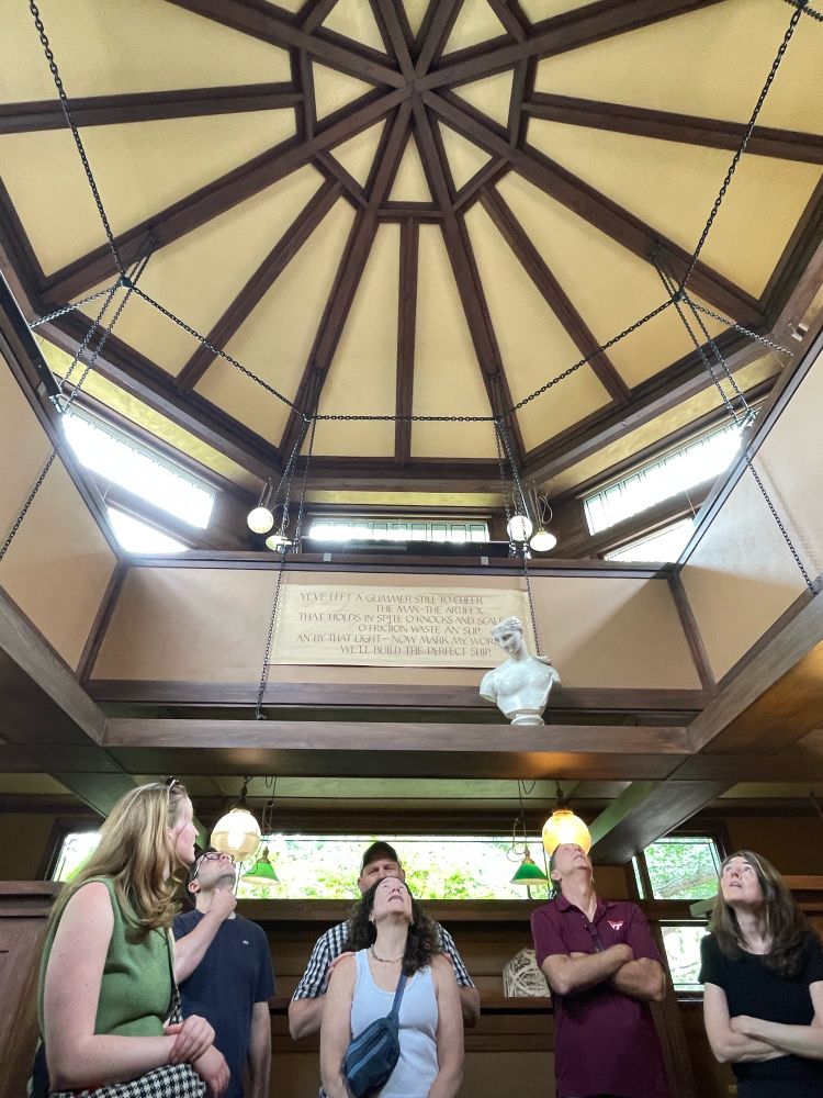 Photo of a wide angle shot of the interior of Frank Lloyd Wright’s studio space, of the octagonal ceiling with several people looking up at it.